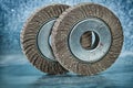 Two abrasive flap discs on metalic background