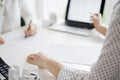 Two accountants using a laptop computer for counting taxes at white desk in office. Business Woman pointing into screen Royalty Free Stock Photo