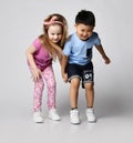 Two active frolic kids friends boy and girl in summer clothes stand together looking down, noticed something on floor