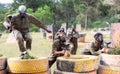 Two active opposing teams with guns playing paintball