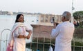 Two active senior couple photographing using mobile phone. Senior man capture the photo and senior woman standing and looking at