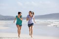 Two active women running and enjoying life at the beach