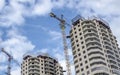 Two adjacent high-rise buildings under construction against a bright blue sky Royalty Free Stock Photo