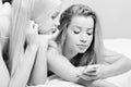 Two adorable blond sisters with mobile cell phone Royalty Free Stock Photo