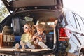 Little cute kids having fun in the trunk of a black car with suitcases. Family road trip Royalty Free Stock Photo