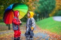 Two adorable children, boy brothers, playing in park with umbrel Royalty Free Stock Photo