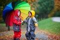 Two adorable children, boy brothers, playing in park with umbrella Royalty Free Stock Photo