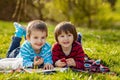 Two adorable cute caucasian boys, lying in the park in a fine su