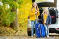 Two adorable girls with a suitcase going on vacations with their parents. Two kids looking forward for a road trip or travel. Autu Royalty Free Stock Photo