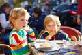 Two adorable kids boys eating ice cream in outdoor cafe. Happy family on sunny day. Healthy children, twins and best Royalty Free Stock Photo