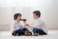 Two adorable little children, boy brothers, having fun eating chocolate bunnies Royalty Free Stock Photo