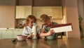 Two adorable little children pouring chocolate flakes into a bowl while preparing cereal with milk for breakfast Royalty Free Stock Photo