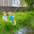 Two adorable little friends fishing with selfmade rod Royalty Free Stock Photo