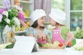 Two adorable little girls in aprons having fun