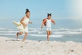 Two adorable little mixed race girls running and having fun at the beach. Two sibling sisters playing on the shore Royalty Free Stock Photo