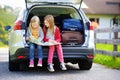 Two adorable little sisters exploring a map before going on vacations with their parents Royalty Free Stock Photo