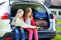 Two adorable little sisters exploring a map before going on vacations with their parents Royalty Free Stock Photo