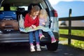 Two adorable little sisters exploring a map before going on vacations with their parents Royalty Free Stock Photo