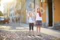 Two adorable little sisters having fun together on warm and sunny summer evening in Desenzano del Garda town, Italy Royalty Free Stock Photo