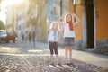 Two adorable little sisters having fun together on warm and sunny summer evening in Desenzano del Garda town Royalty Free Stock Photo