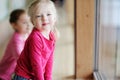 Two adorable little sisters by the window Royalty Free Stock Photo