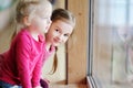 Two adorable little sisters by the window Royalty Free Stock Photo