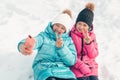 Two adorable teenage girls taking a selfie in a winter park on a sunny day Royalty Free Stock Photo