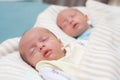 Two adorable twin babies sleeping in the same pose