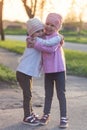 Two adorable twin little sisters laughing and hugging each other