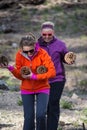 Two adult females happily walk with an armful of large Jeffrey pine cones found on the forest floor