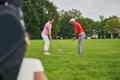 Two adult players perfecting their golf grips