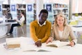 Two adult students studying together in public library Royalty Free Stock Photo