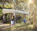 Two adventure loving men carrying a canoe into a river