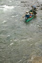 Two adventurers and canoe in wild river rapids Royalty Free Stock Photo