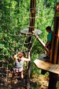 Two adventurers walk across a rope web