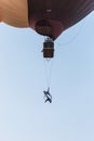 Two aerial acrobats show a performance on a trapeze suspended from a hot air balloon at the hot air balloon festival