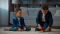 Two African American brothers little ethnic boys children siblings friends kids at home floor in living room playing Royalty Free Stock Photo