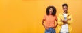 Two african american friends standing over orange background, girl thinks idea is awesome feeling excited and joyful