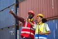 Two African american male and female worker check and control loading freight containers from Cargo freight ship for import export Royalty Free Stock Photo