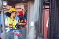 Two African American male and female worker in uniform and helmet driving and operating on diesel container forklift truck at Royalty Free Stock Photo