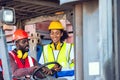 Two African American male and female worker in uniform and helmet driving and operating on diesel container forklift truck at Royalty Free Stock Photo