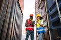 Two African american male and female worker using tablet and checking control loading freight containers from Cargo freight ship