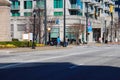 Two African American men standing on a street corner at an intersection with one holding an electric scooter