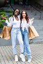 Two african and caucasian woman friends on vacation shopping outdoors