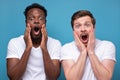 Two african and caucasian men looking with shocked expression, with mouth wide open Royalty Free Stock Photo