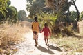 Two African Children Walk Down Natural Road in African Village