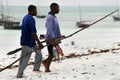 Two African fisherman divers carry home caught fish.