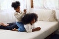 African girl siblings are having fun and tease each other in the bedroom during the holidays.