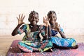 Two African Girls Sisters Friends wear traditional Clothes Posing indoor white room and with confetti