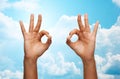 Two african hands showing ok sign over blue sky Royalty Free Stock Photo